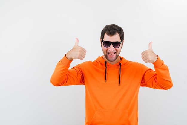 L'homme à lunettes montre un geste parfait avec les pouces sur fond blanc