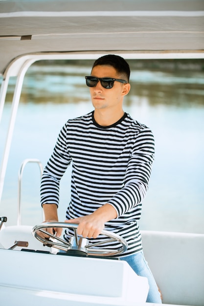 Homme avec des lunettes naviguant sur un bateau