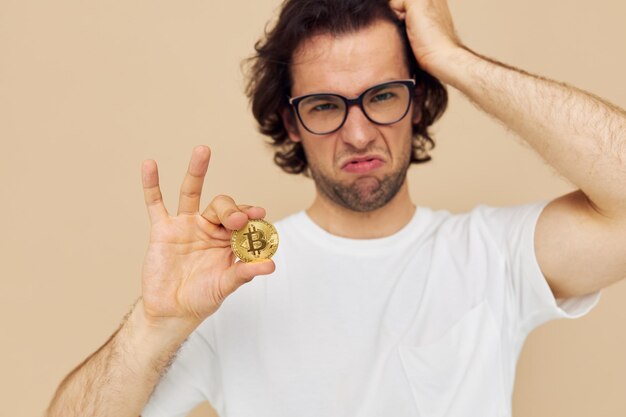Photo homme avec des lunettes d'or bitcoin dans les mains