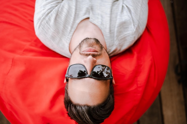 Photo homme avec des lunettes de soleil allongé profitant des vacances d'été