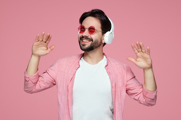 Homme avec des lunettes de soleil, écouter de la musique dans des écouteurs tout en dansant