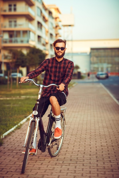 Homme à Lunettes De Soleil Faisant Du Vélo Dans La Rue De La Ville