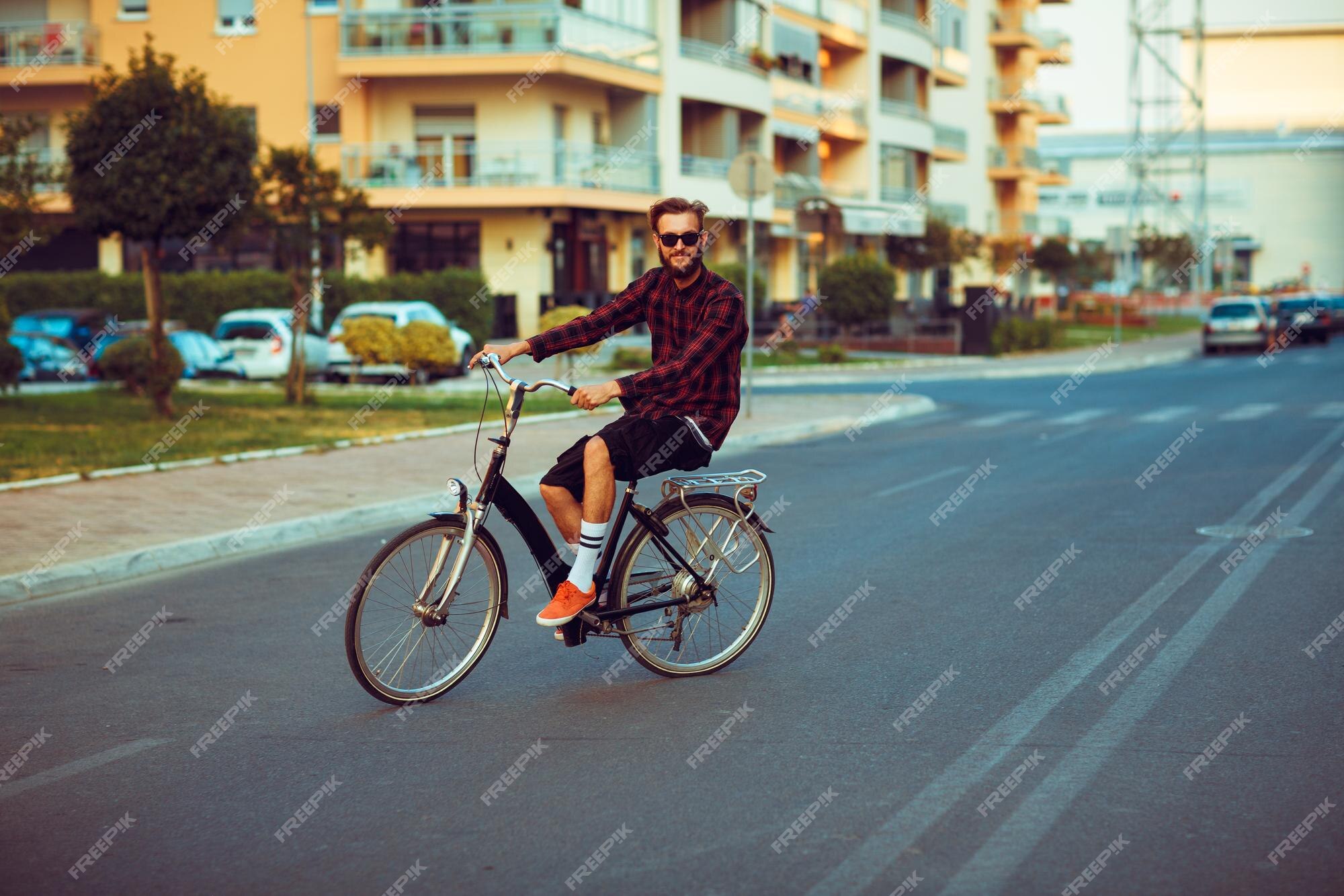 Homme à Lunettes De Soleil Faisant Du Vélo Dans La Rue De La Ville