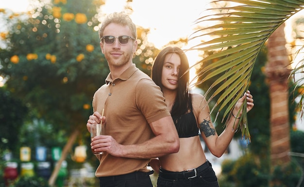 Homme à lunettes de soleil femme en soutien-gorge noir Heureux jeune couple est ensemble pendant leurs vacances à l'extérieur à la journée ensoleillée