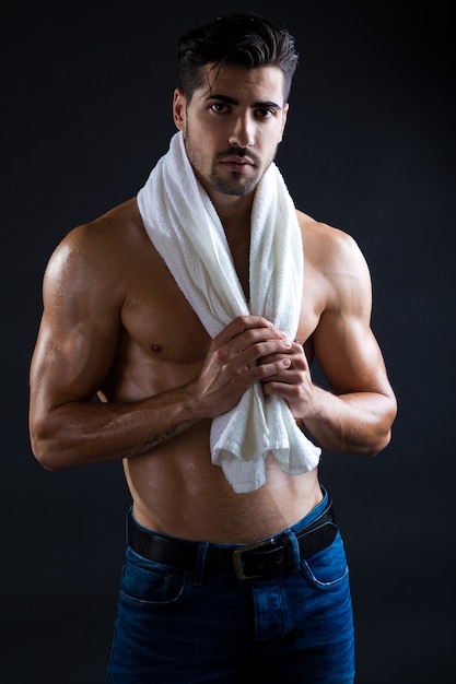 Homme magnifique et musclé en fond sombre.