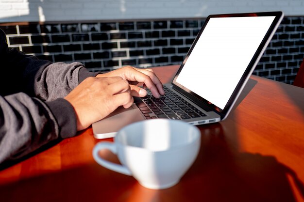 Homme de main d&#39;homme d&#39;affaires travaillant sur un ordinateur portable sur un bureau en bois Ordinateur portable avec un écran blanc sur table