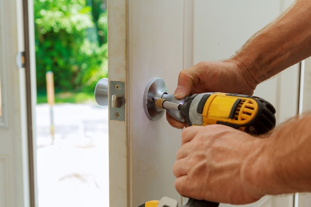 Homme à main avec tournevis Installe le bouton de porte.