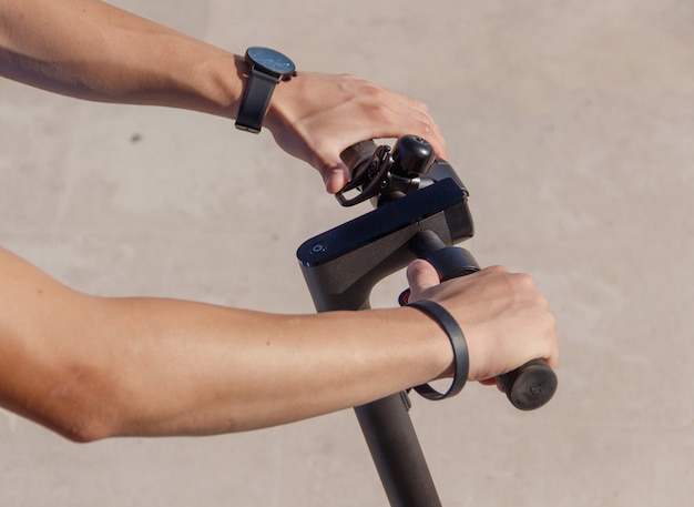 L'homme les mains sur un guidon de scooter électrique