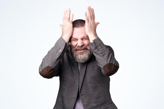 Homme avec les mains sur les tempes difficile à penser