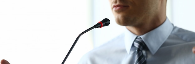 L'homme à la maison parle devant le microphone en conférence