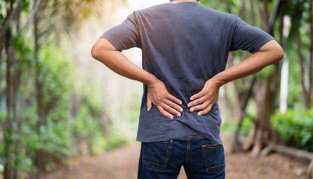 Un homme mal à l'aise tient le bas du dos, ce qui signifie des maux de dos et des problèmes de santé.