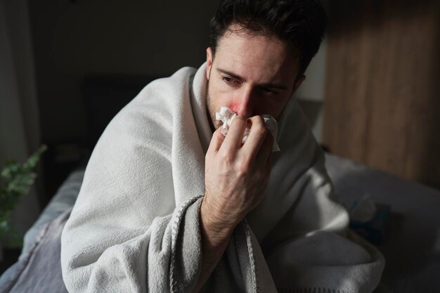 Photo l'homme malade assis sous la couverture