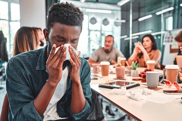 Homme malade éternuant au bureau Virus de la grippe Coronavirus