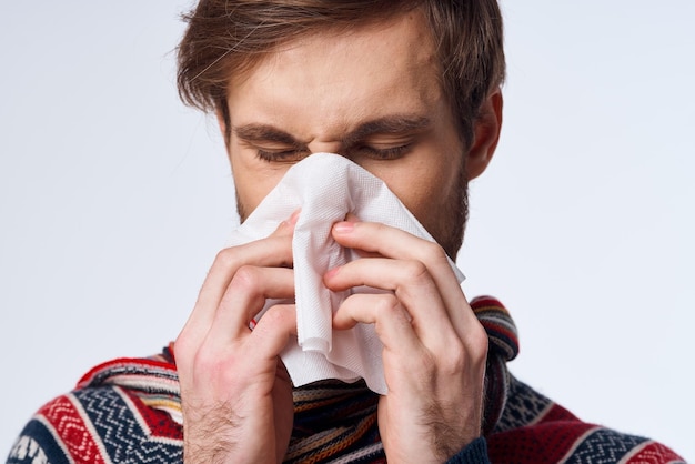 Homme malade avec un mouchoir problème de santé symptômes de la grippe fond clair photo de haute qualité