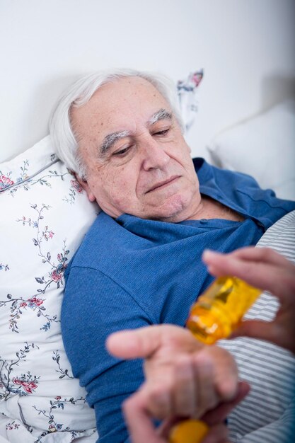 Homme malade recevant des comprimés