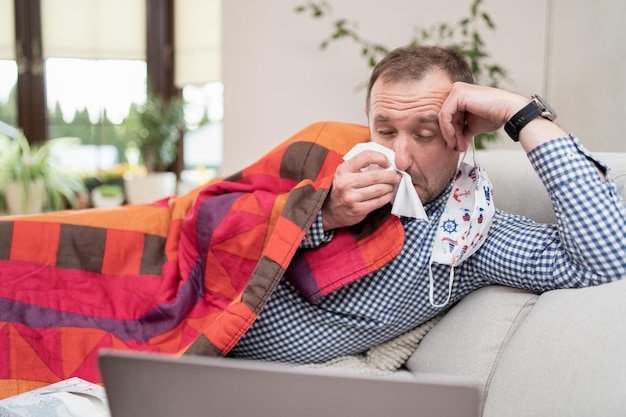 Un homme malade se moucher allongé sur le canapé le virus propage le danger caucasien