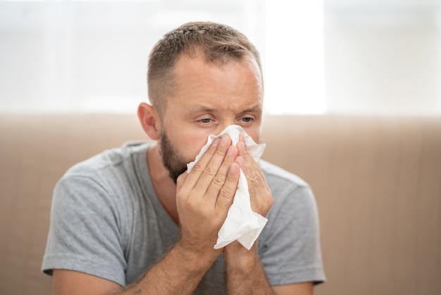 Homme malade se moucher et éternuer dans les tissus