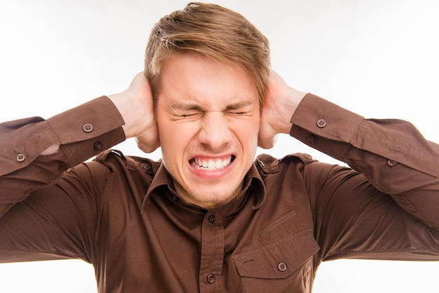 homme malheureux et agacé fermant les oreilles avec les mains