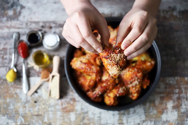 L'homme mange des ailes de poulet. Ailes de poulet frites.