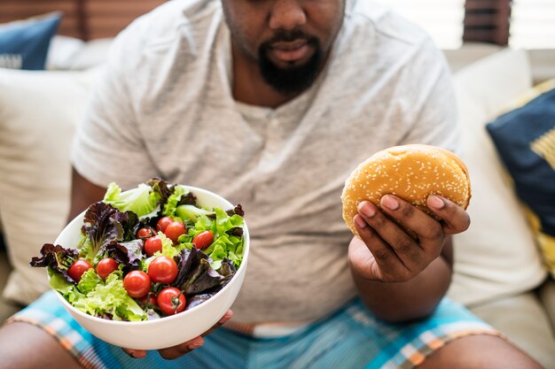 Homme mangeant un gros hamburger