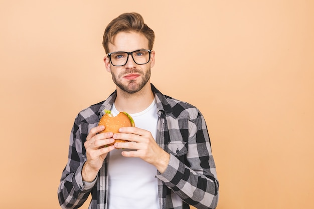 Homme mangeant un hamburger dans le studio