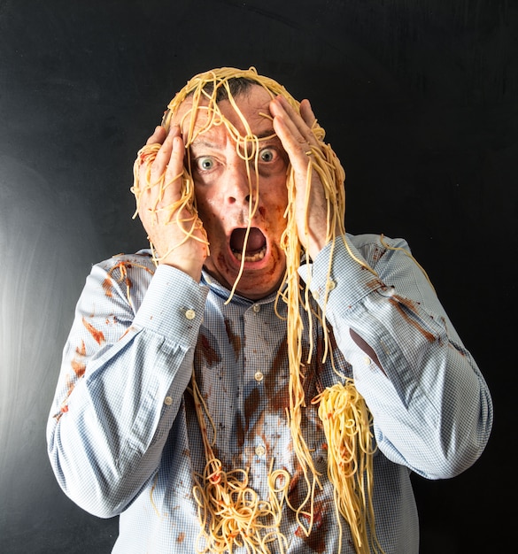 Homme mangeant des spaghettis à la sauce tomate dans la tête