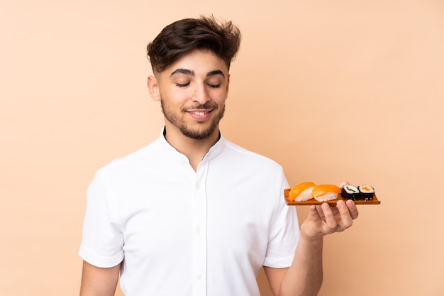 Homme mangeant des sushis isolés sur beige