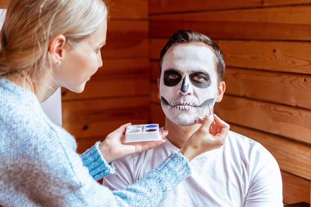 Homme avec maquillage effrayant artistique debout préparé pour la fête d'Halloween