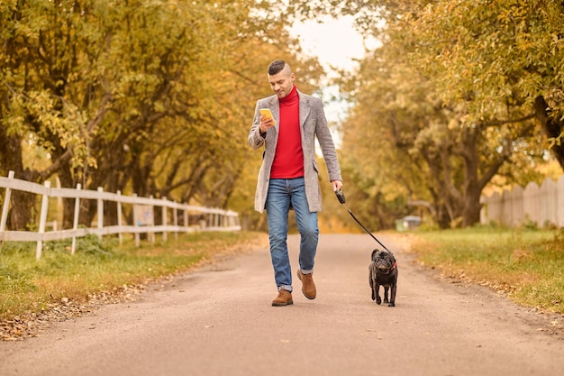 Photo homme marchant avec un chien dans un parc