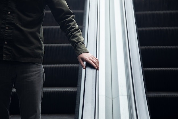 Un homme marchant dans l'escalator en acier dans le métro