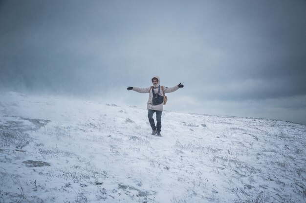 Homme marchant dans la tempête de neige dans les montagnes