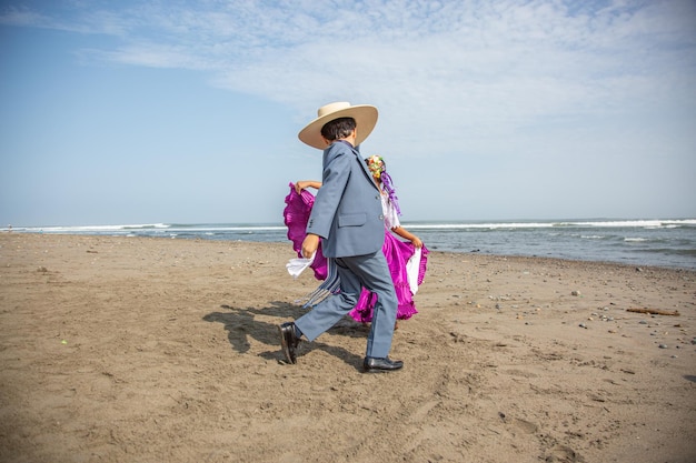 un homme marchant sur la plage avec un chapeau de paille sur la tête