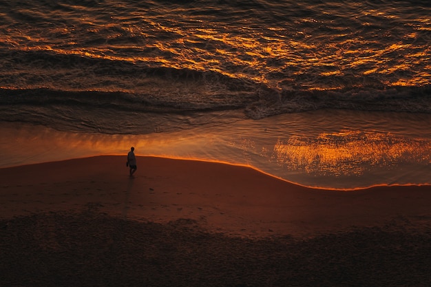 Homme marchant sur la plage la nuit