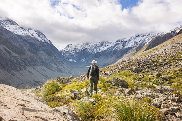 Homme marchant sur un sentier de randonnée avec le parc national du mont Cook, belle région de montagnes. Tramping, randonnée en Nouvelle-Zélande.