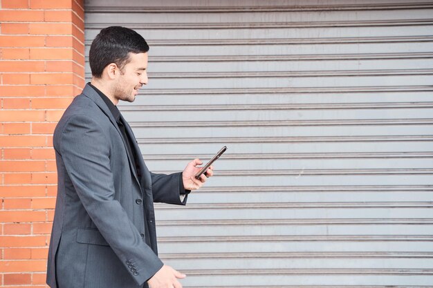 un homme marchant avec un smartphone à la main