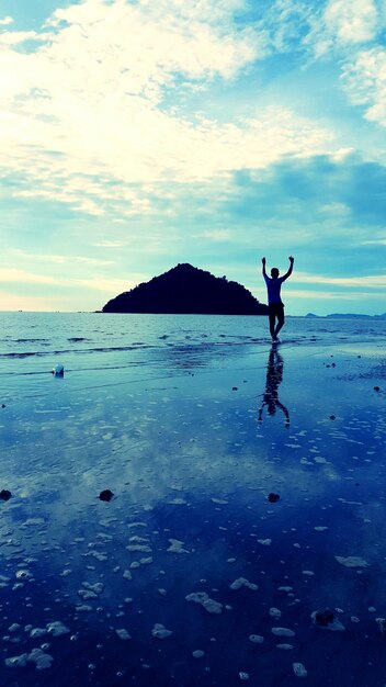 Photo un homme marche sur la plage contre le ciel.