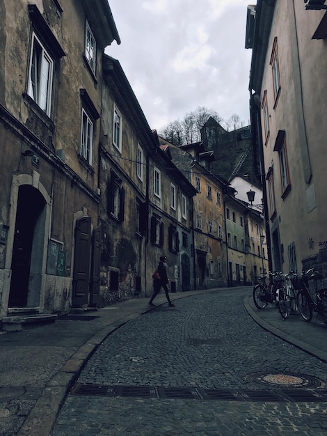 Un homme marche sur la route le long des bâtiments.