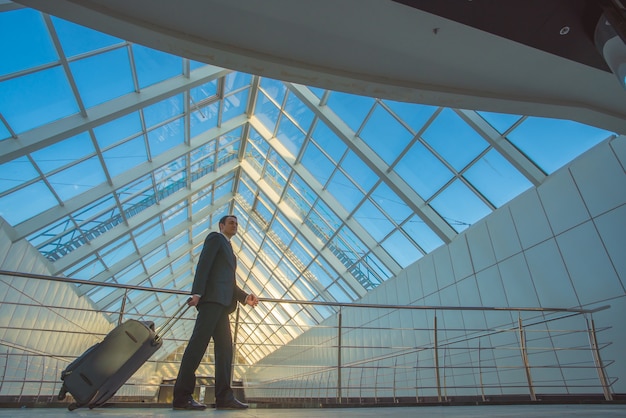 L'homme marche avec une valise dans le centre d'affaires