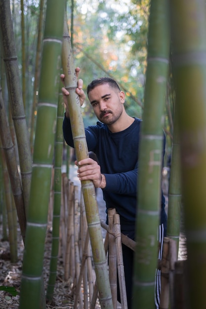 Photo un homme marocain tenant une tige de bambou dans un parc public