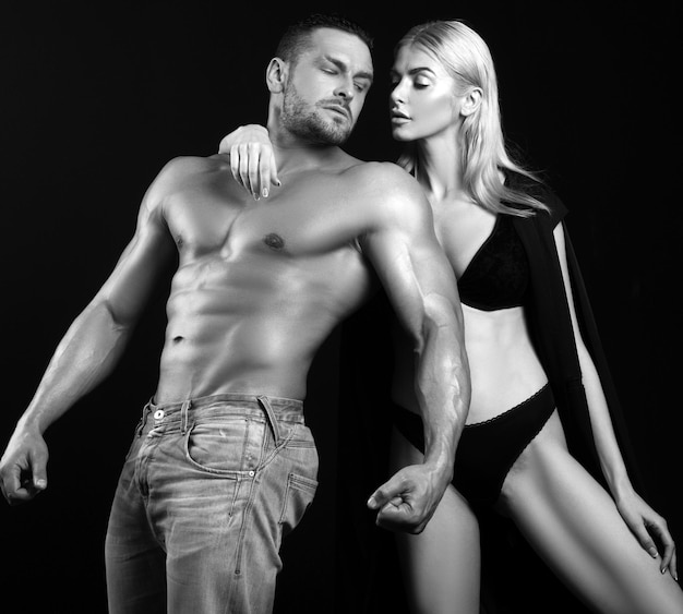 Photo homme masculin musclé posant avec sa femme sur fond noir fond noir