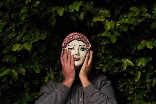 un homme avec un masque en céramique faisant des gestes avec les mains