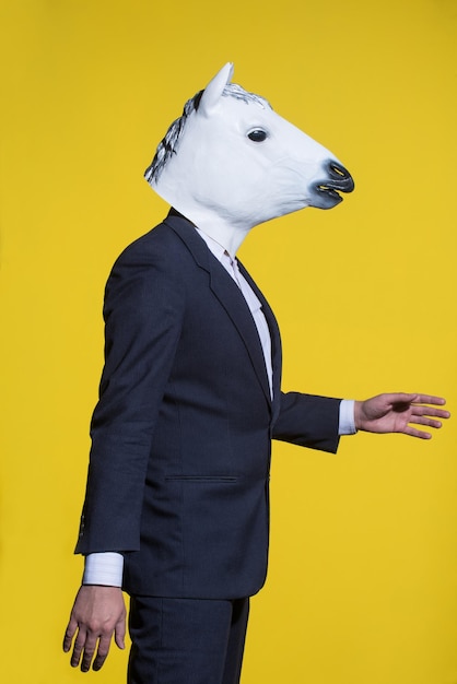 Homme avec masque de cheval sur fond jaune