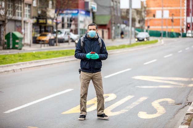 Homme avec un masque de protection sur son visage est debout dans la rue