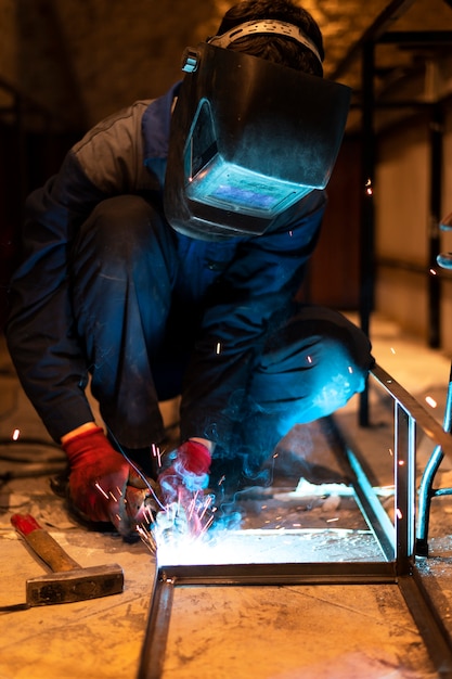 Homme avec masque de soudage métal dans l'atelier