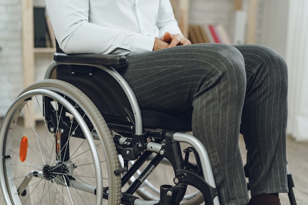 Homme méconnaissable assis en fauteuil roulant se bouchent