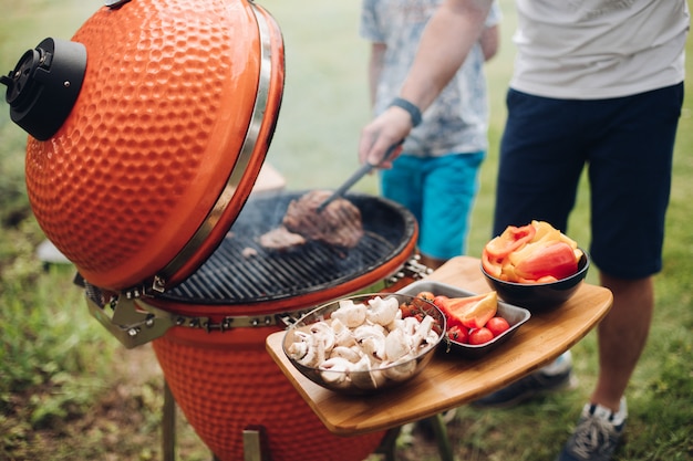 Homme méconnaissable faisant cuire de la viande sur le gril.