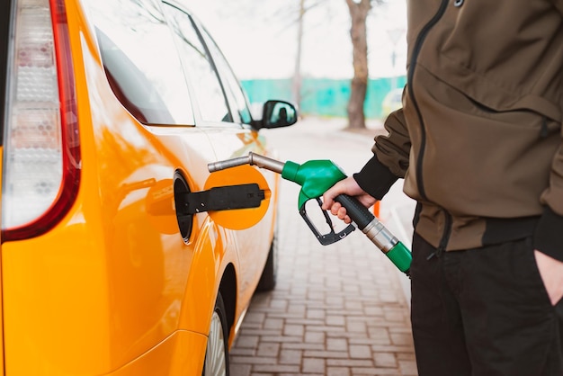 Homme méconnaissable faisant le plein d'une voiture à partir d'une station-service remplissant de l'essence de benzine dans la voiture à la station-service Concept de prix élevés de l'essence