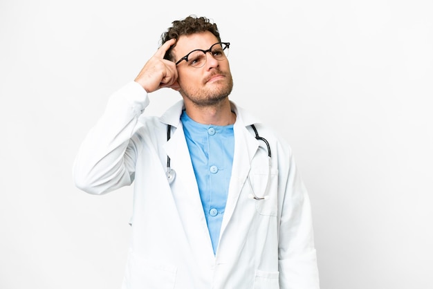 Homme médecin brésilien sur fond blanc isolé ayant des doutes et avec une expression de visage confuse