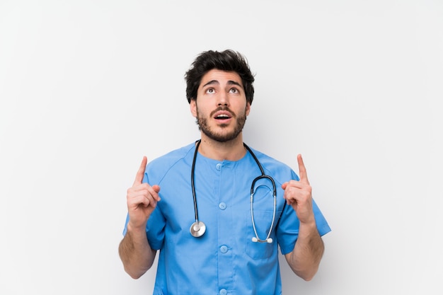 Homme médecin chirurgien sur un mur blanc isolé pointant avec l&#39;index une excellente idée