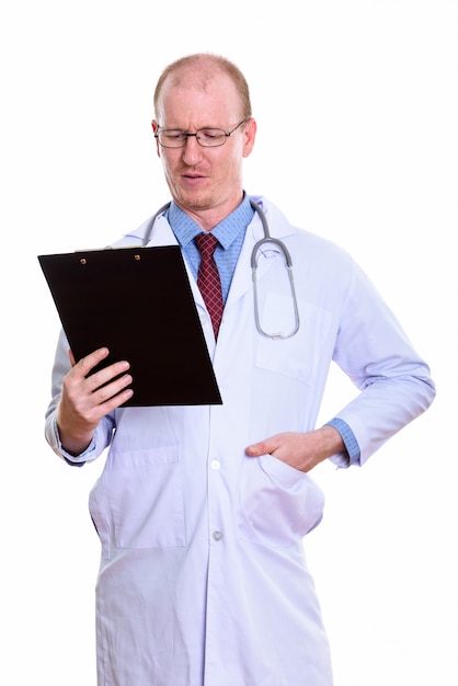 Homme médecin debout lors de la lecture sur le presse-papiers isolé sur blanc